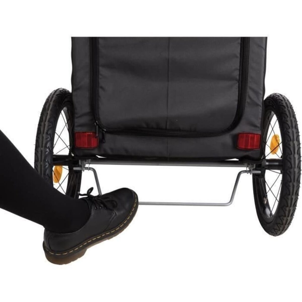 Ein schwarzer Anhänger für ein Fahrrad, mit zwei Rädern und einem Fuß in einem Schuh.