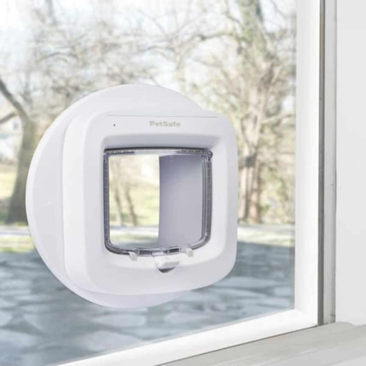 Weiße Haustiertür an einem Fenster installiert. Die Tür hat eine transparente Klappe.