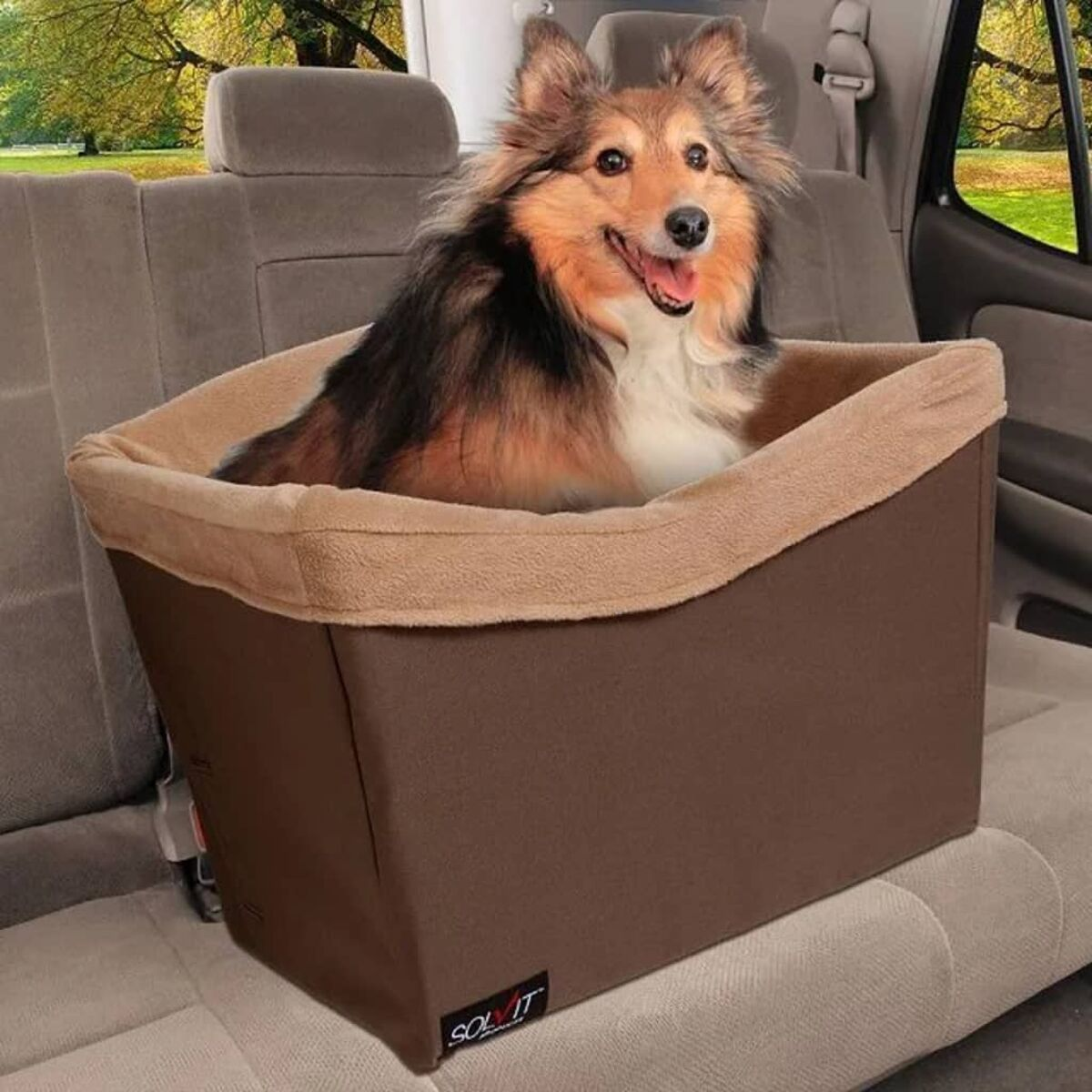 Ein Hund in einem braunen Autositz, im Innenraum des Autos.