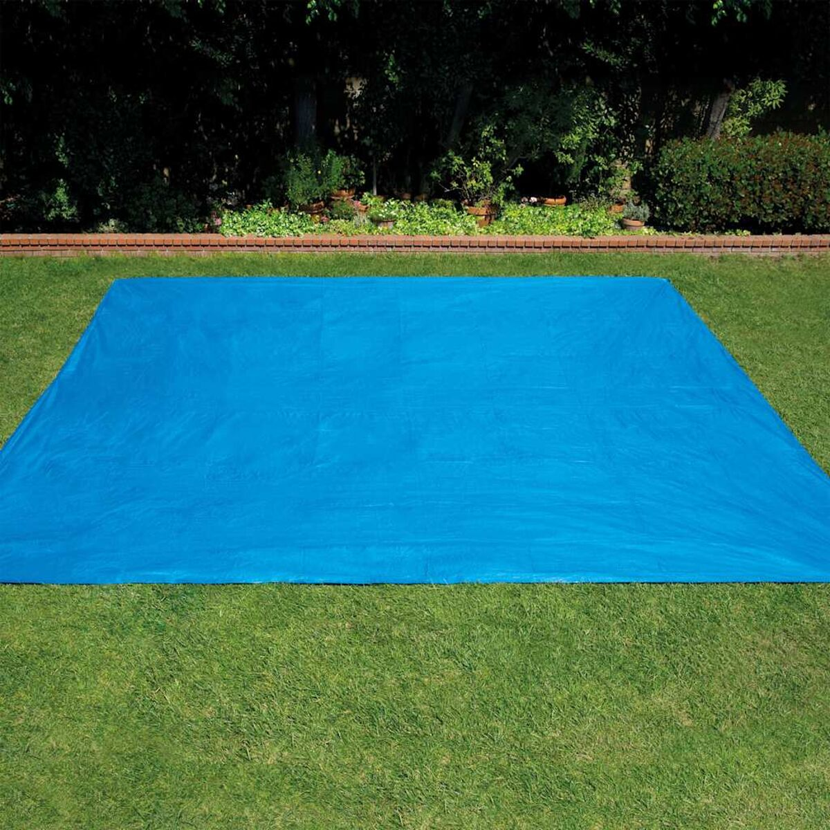Telone blu su erba verde. Alberi e luce solare sullo sfondo.