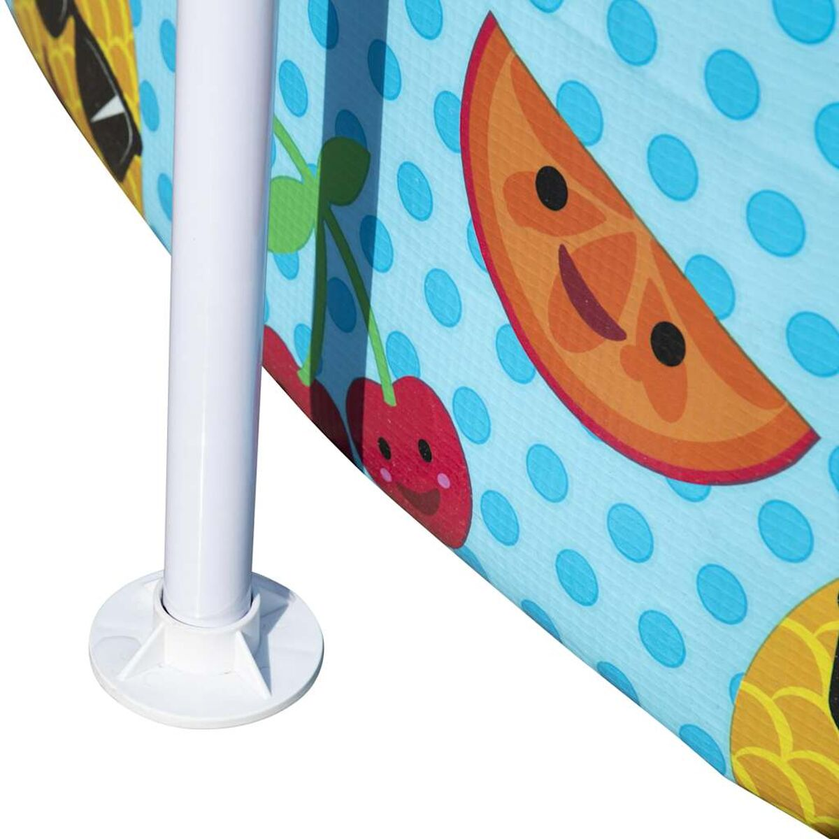 Ein blauer Sonnenschirm mit Fruchtdesigns und Polka Dots. Ein weißer Pfosten mit weißem Sockel.