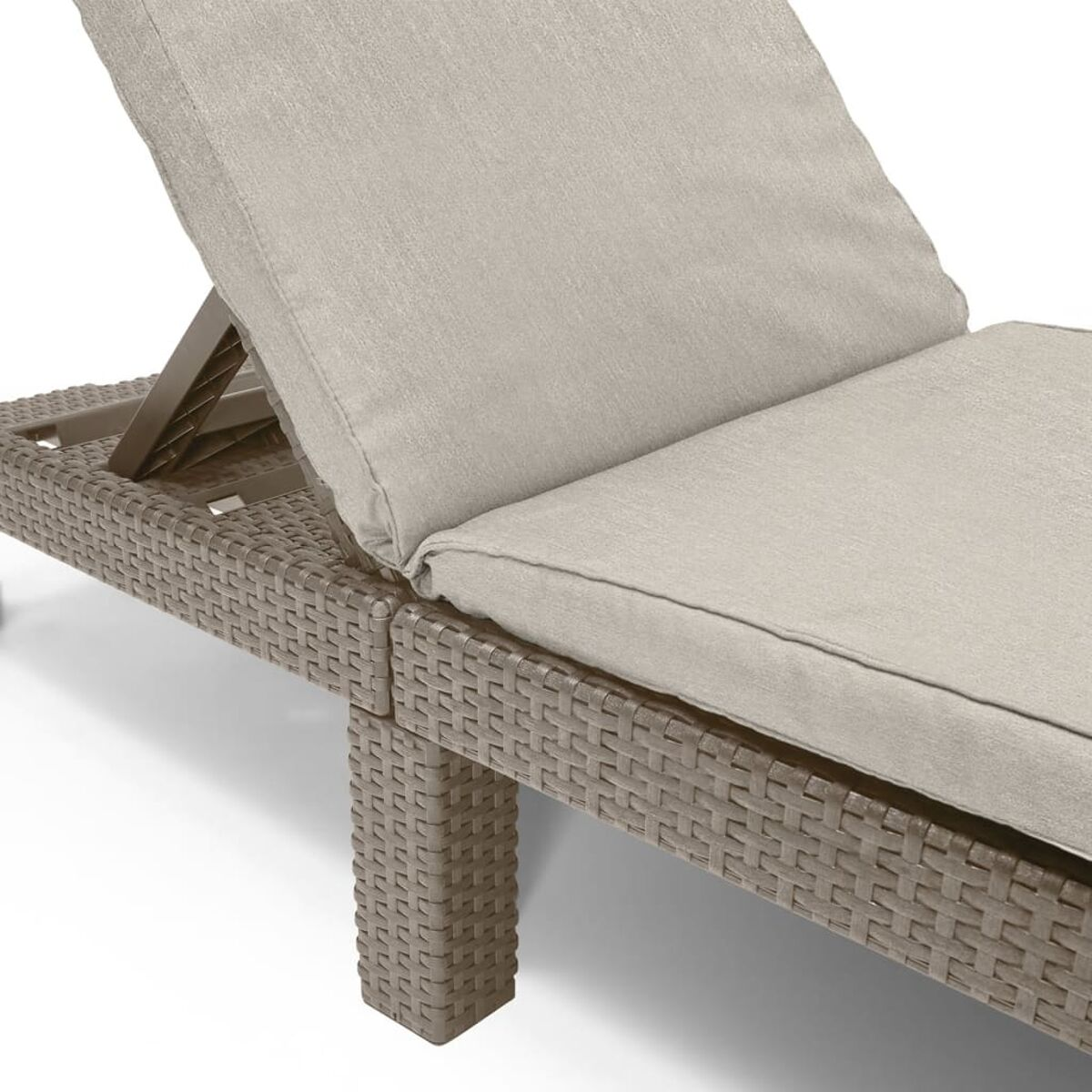 Nahaufnahme eines beigefarbenen Liegestuhls für draußen. Beige Kissen und Untergestell im Rattan-Stil.