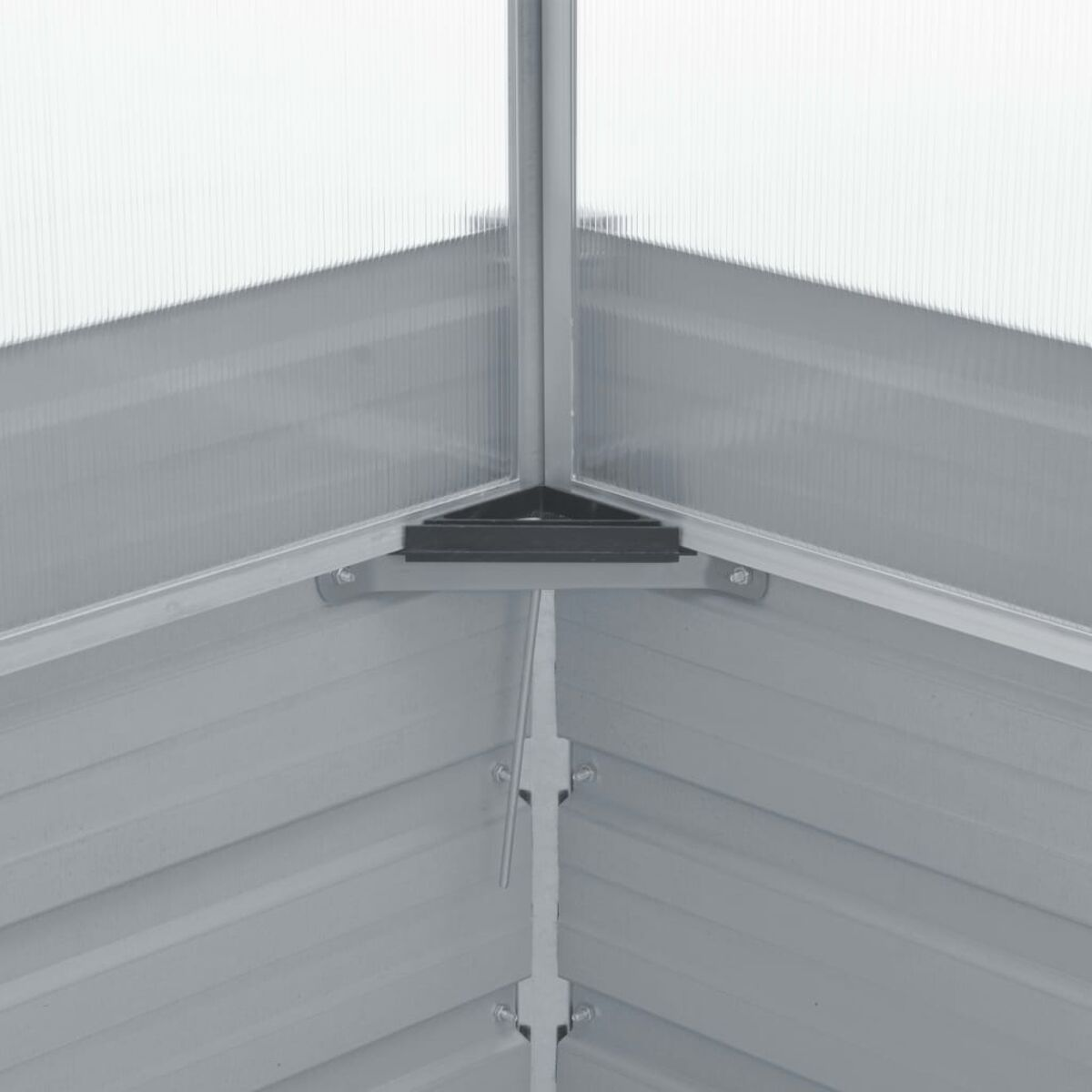 Im Inneren eines Metallrahmen-Gewächshauses sind Dachbalken und klare Paneele zu sehen.