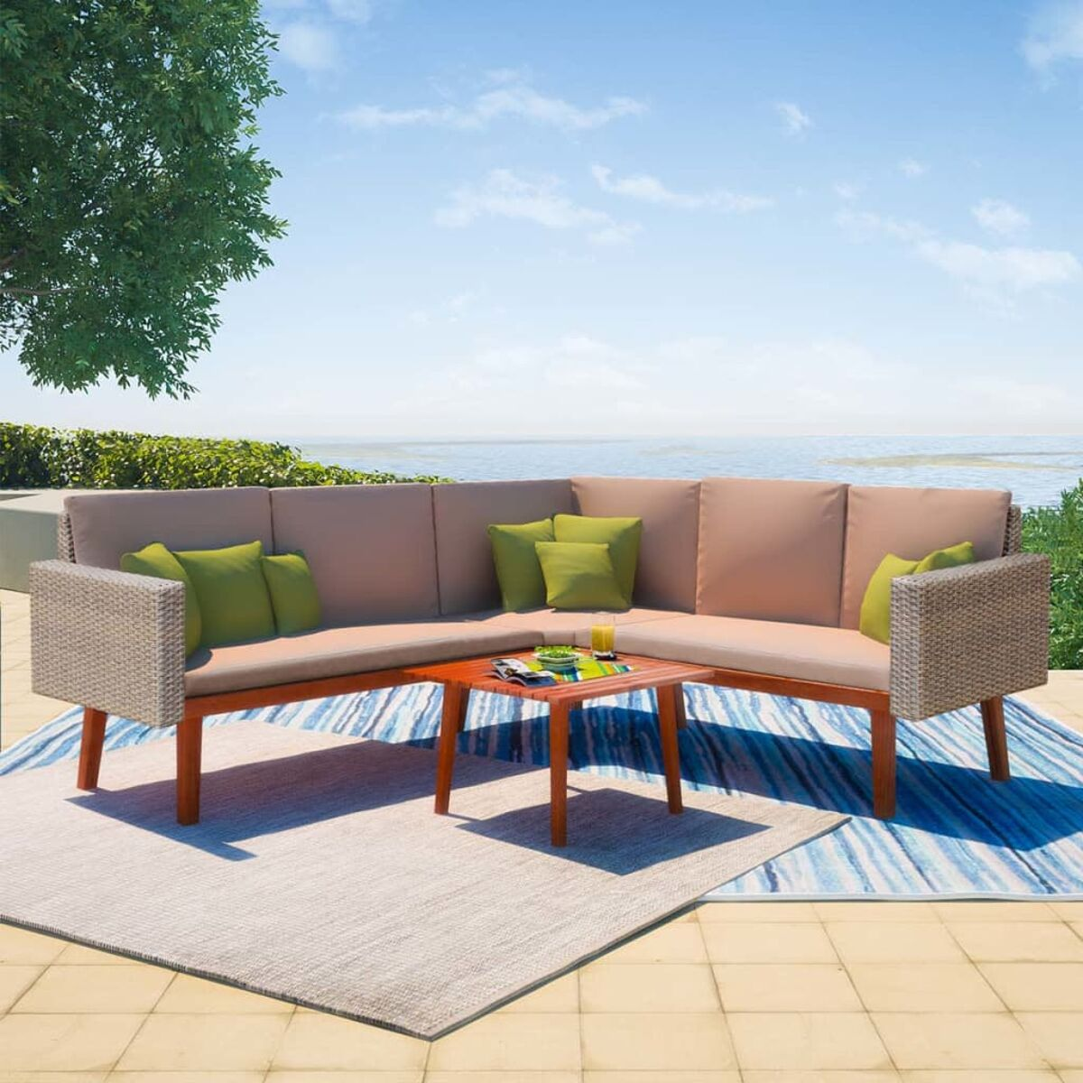 Outdoor-Sitzgruppe mit Ecksofa, Couchtisch und Teppich. Szene am Meer, sonnig.