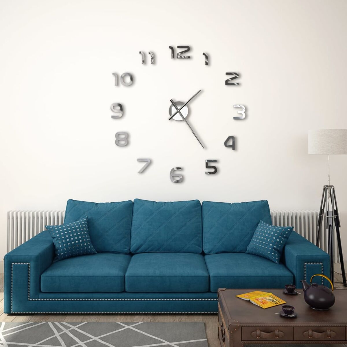 Eine große Wanduhr mit silbernen Zahlen und Zeigern. Ein blaues Sofa und Dekor sind im Bild.