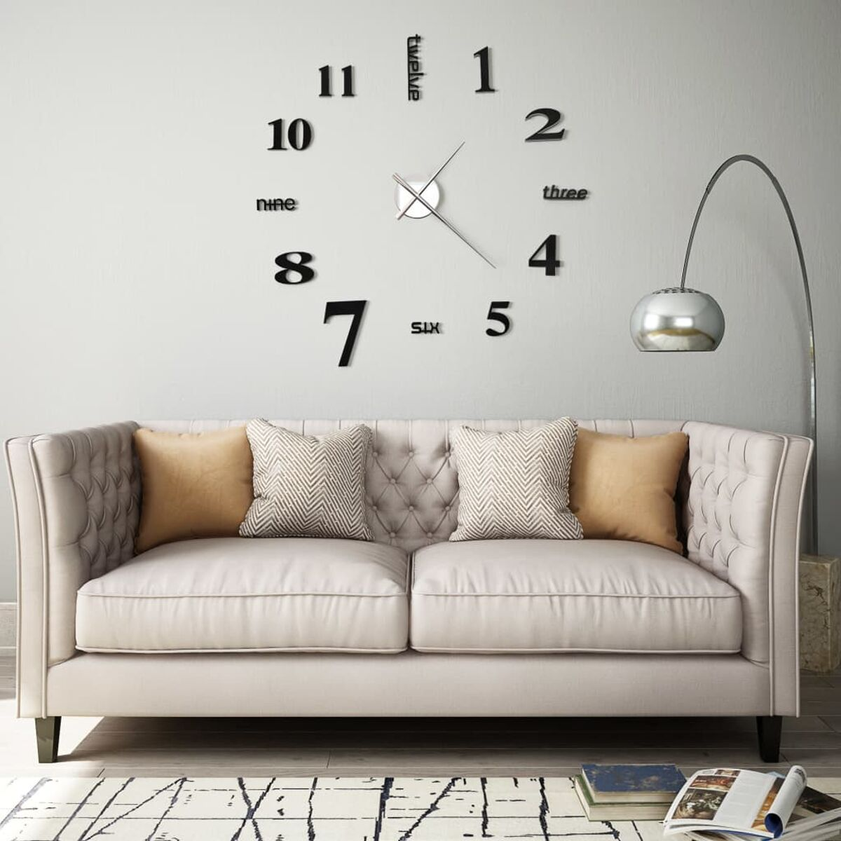 Eine Wanduhr mit schwarzen Zahlen und Zeigern, über einem Sofa mit Kissen und einer Stehlampe.