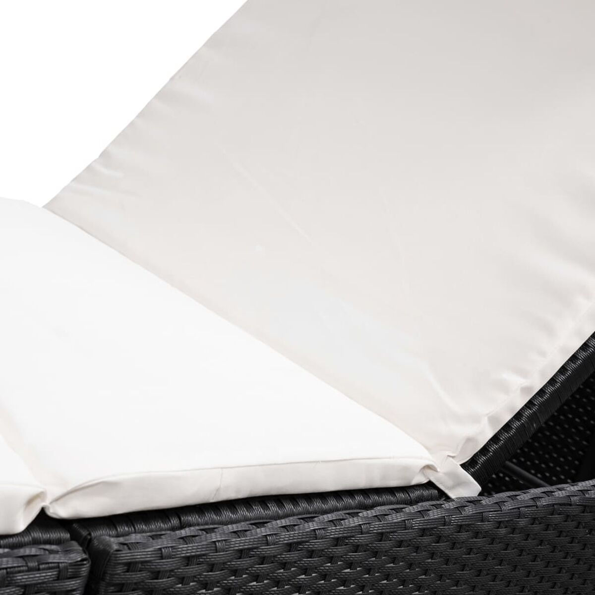 Nahaufnahme von weißen Kissen auf einem dunklen, gewebten Outdoor-Sofa.