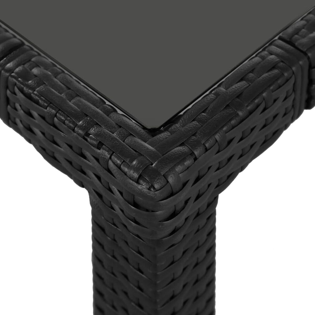 Nahaufnahme einer schwarzen Rattan-Tischecke. Die gewebte Textur ist sichtbar.