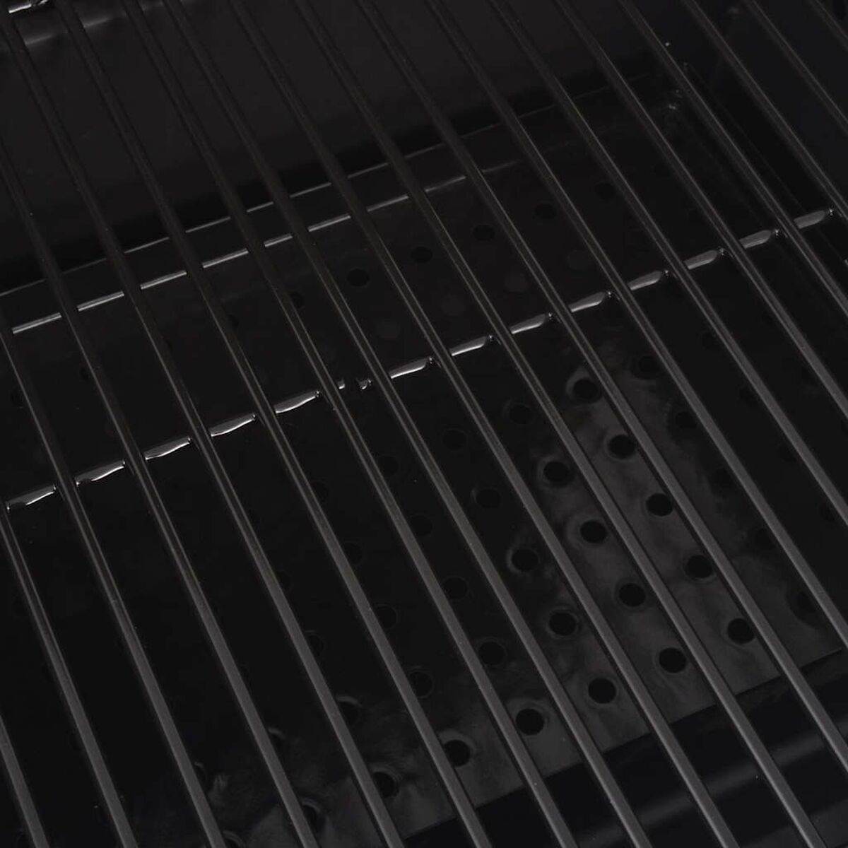 Primo piano di una griglia nera con barre metalliche parallele.