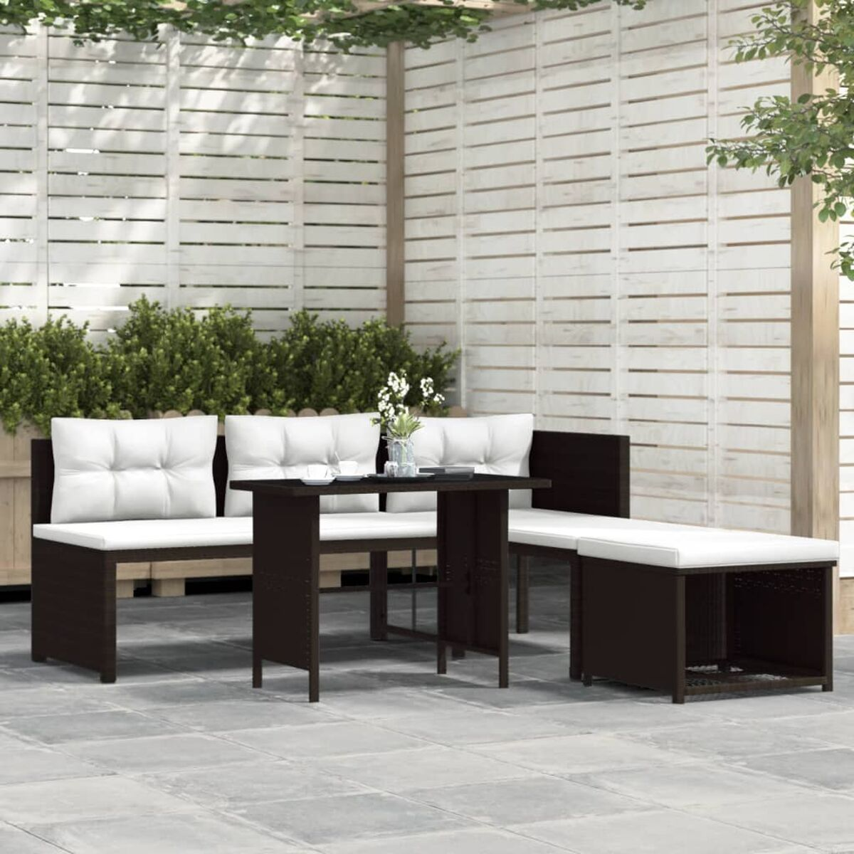 Outdoor-Sitzgruppe: 2 Sofas, kleiner Tisch und eine Bank mit weißen Kissen.