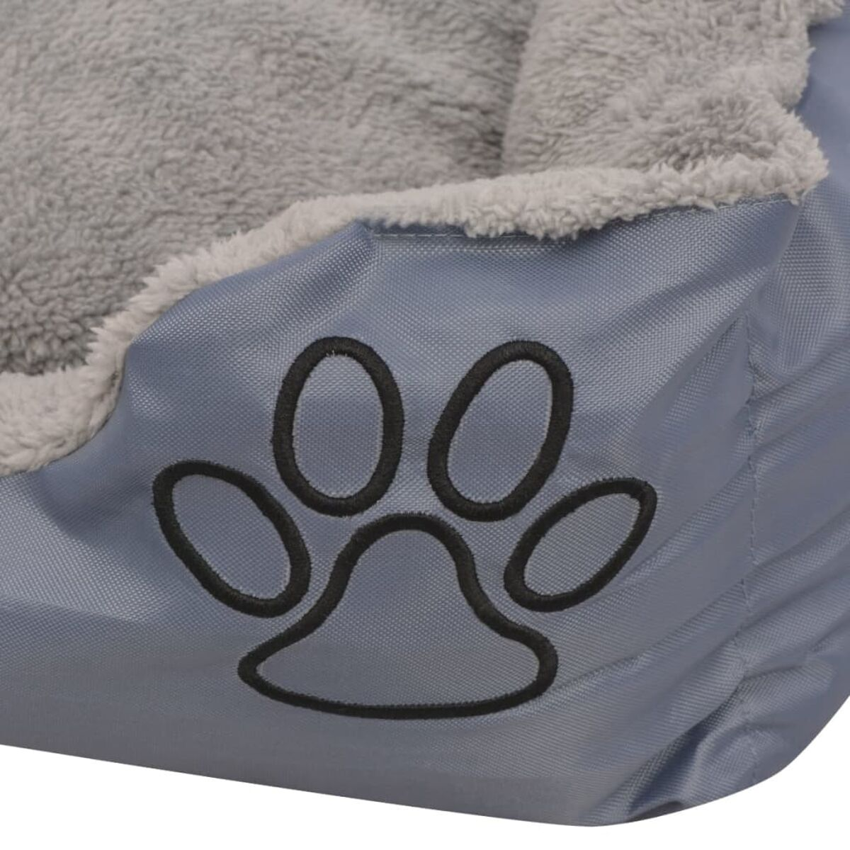 Nahaufnahme eines Hundebetts. Es ist grau mit Pfotenabdruck und flauschigem Rand.