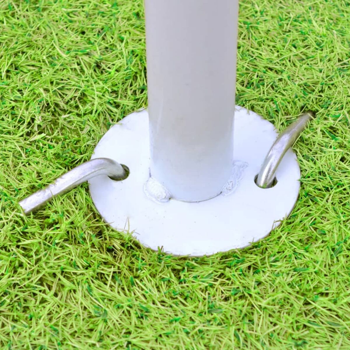 Nahaufnahme einer weißen Pfahlbasis mit Haken im grünen Gras.