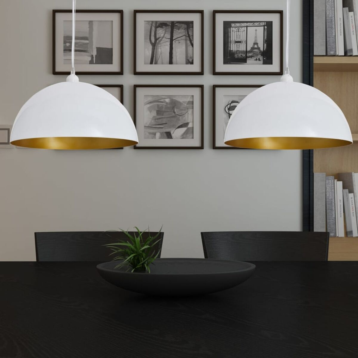 Zwei weiße und goldene Pendelleuchten über einem schwarzen Tisch mit einem schwarzen Mittelstück, Kunst an der Wand.