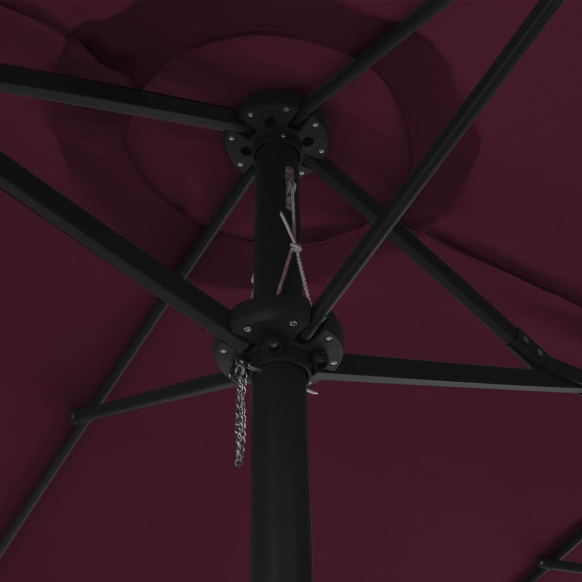 Nahaufnahme des Mechanismus eines Schirms. Roter Stoff und schwarze Streben.