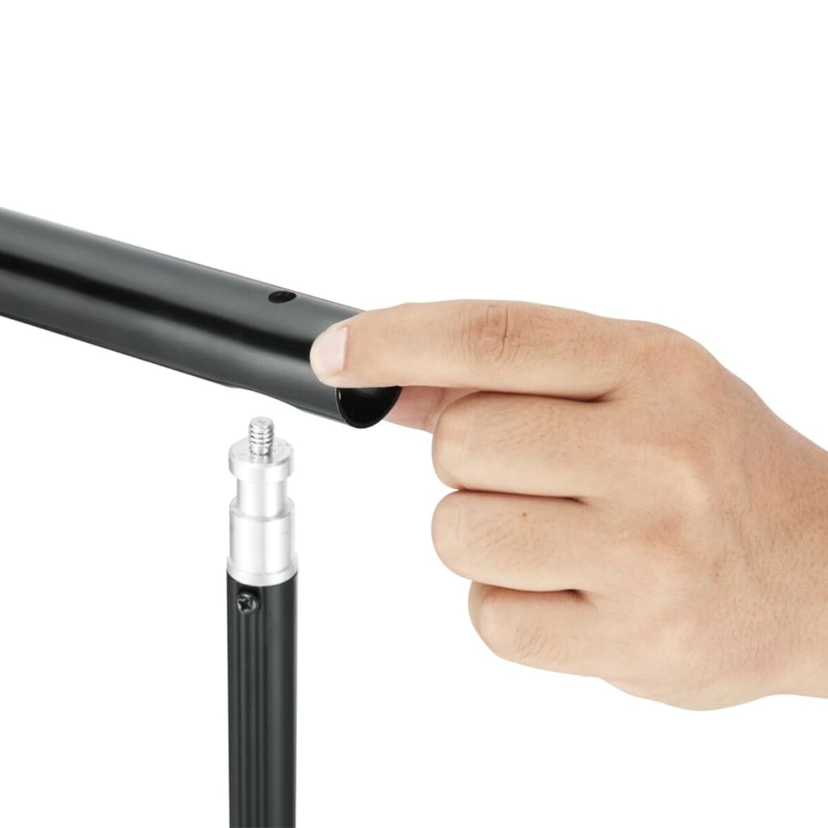 Hand, die eine schwarze Metallstange neben einer kleineren Stange mit silbernem Aufsatz hält.