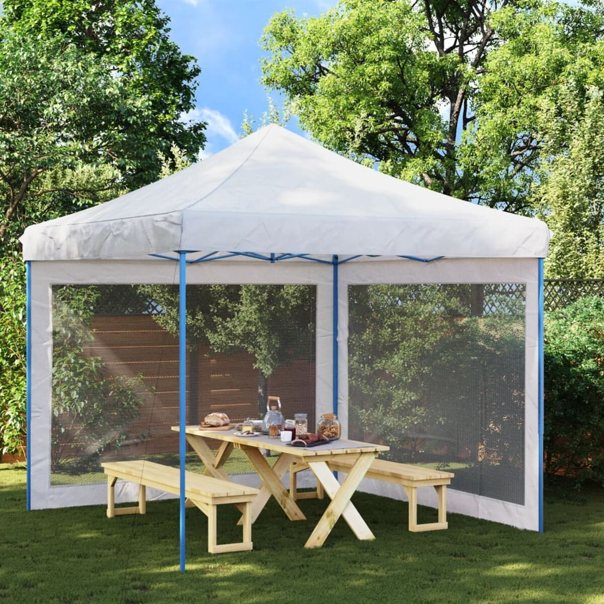 Weißes Zelt mit Baldachin in einem Garten. Ein Tisch und zwei Bänke sind darin. Bäume sind im Hintergrund.