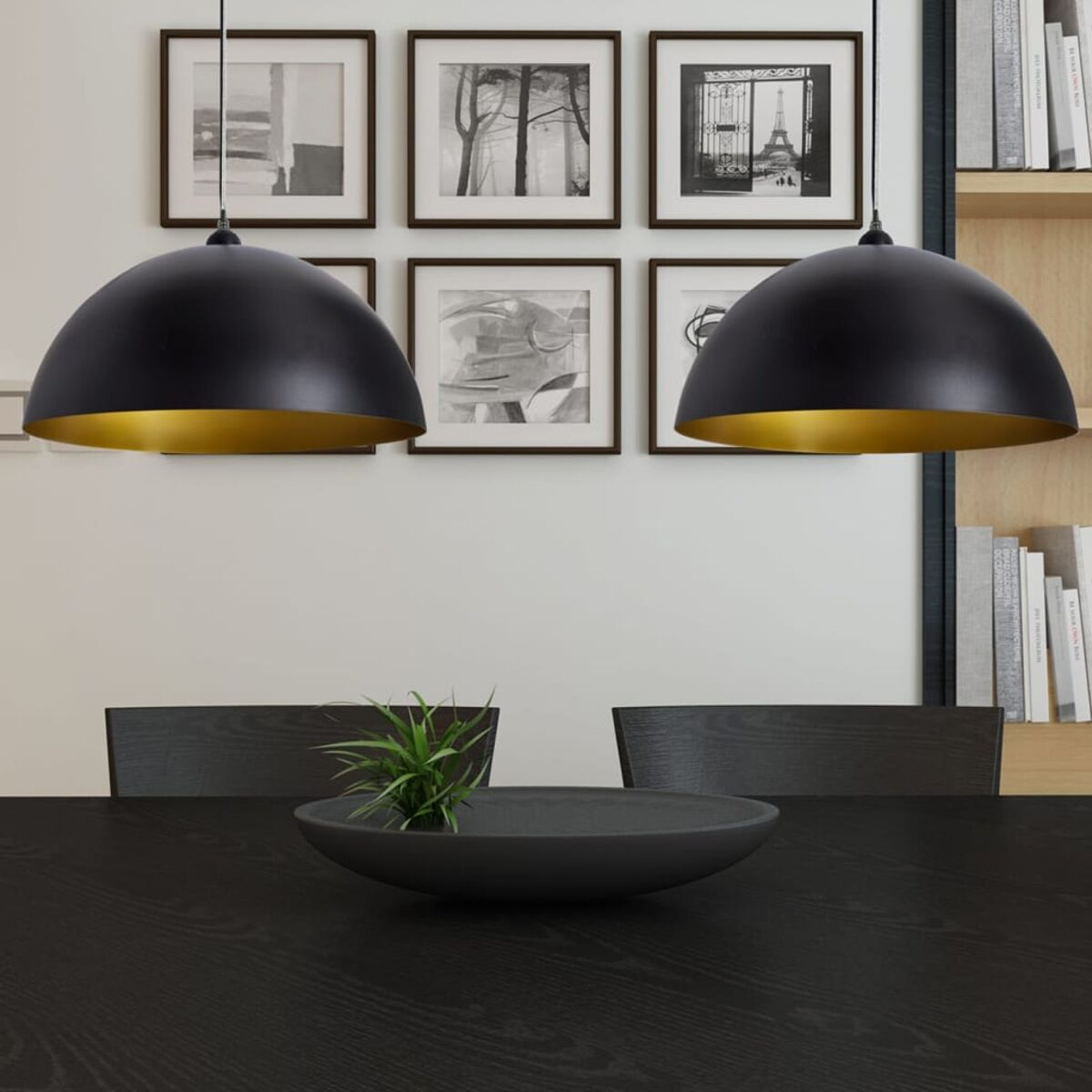 Zwei schwarze Pendelleuchten mit goldenem Innenraum über einem dunklen Holztisch mit Deko.