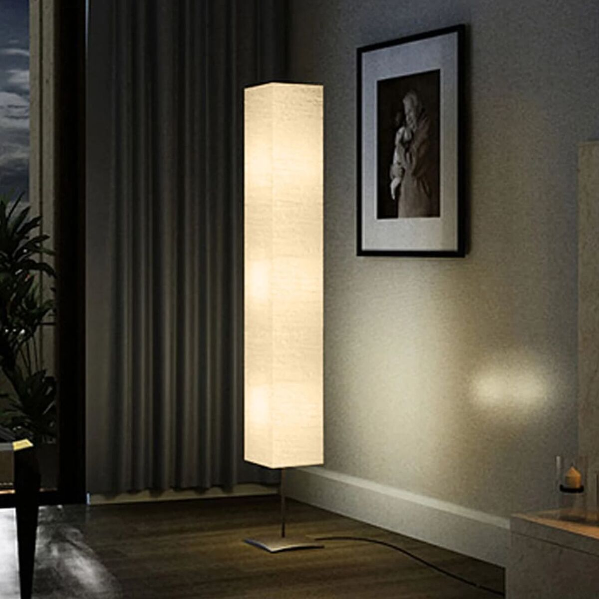 Hohe, rechteckige Lampe mit weichem Licht. Bild an der Wand, dunkler Vorhang im Hintergrund.