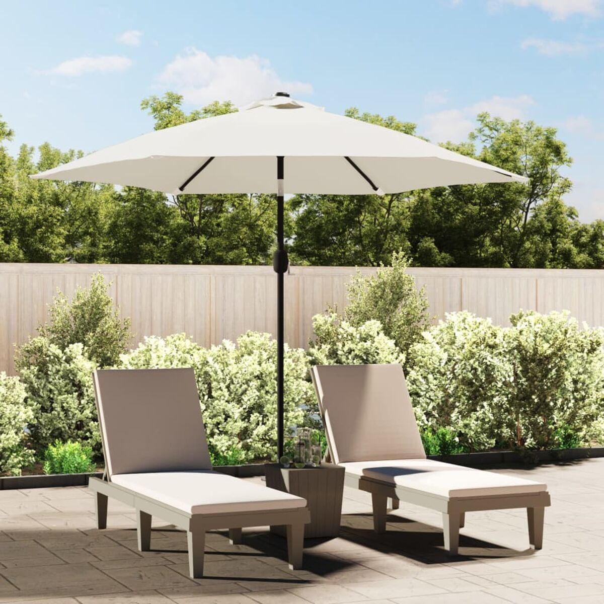 Zwei Liegestühle, ein cremefarbener Sonnenschirm, ein kleiner Tisch und Büsche im Garten.