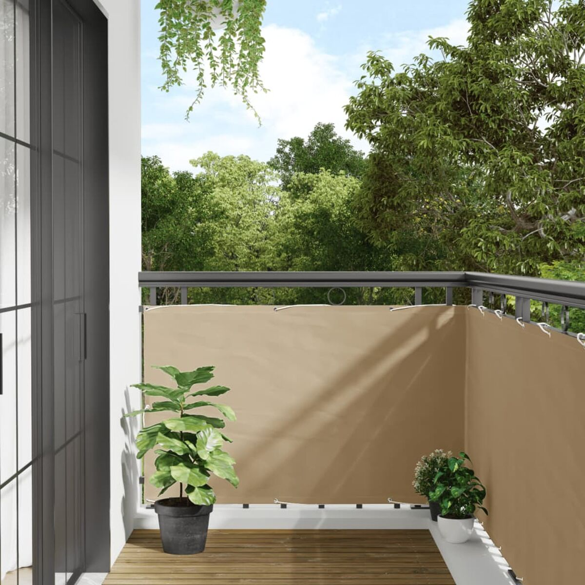 Balkon mit beigefarbenem Sichtschutz, Pflanzen und Bäumen im Hintergrund unter blauem Himmel.