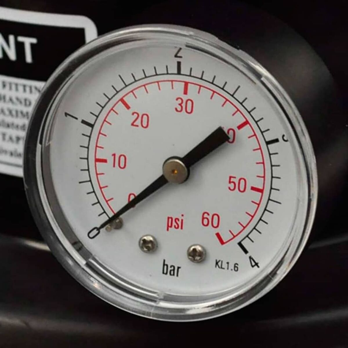 Nahaufnahme eines Manometers mit psi- und bar-Anzeigen und einem schwarzen Zeiger.