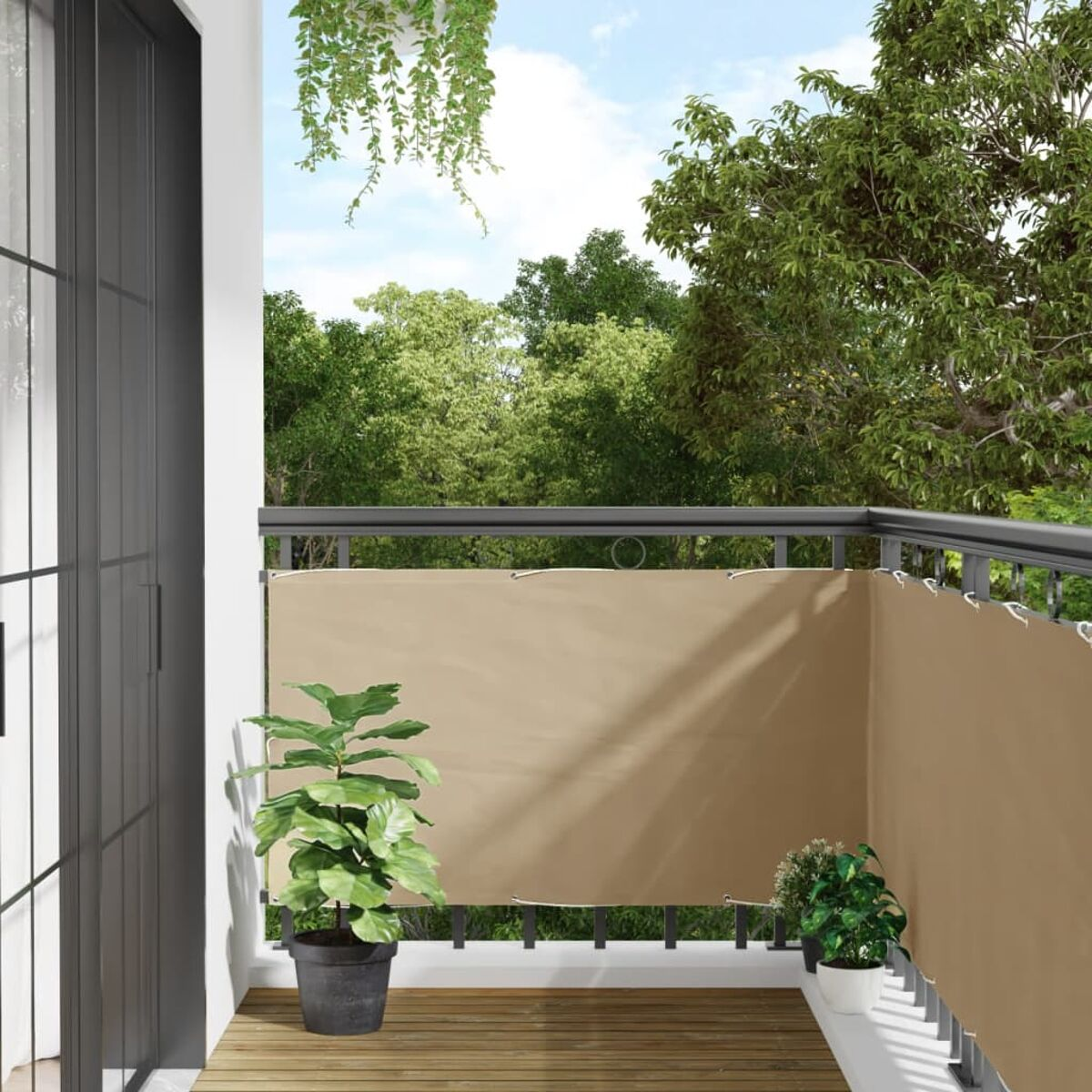 Balkon mit beigem Sichtschutz und schwarzem Geländer. Pflanzen im Vordergrund, Bäume im Hintergrund.