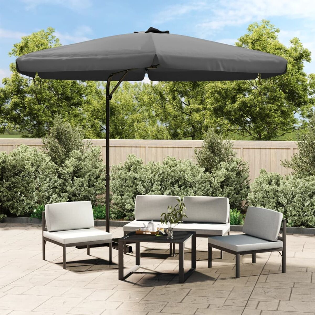 Gartenmöbel-Set mit großem Sonnenschirm, Tischen, Stühlen und Bäumen im Hintergrund.
