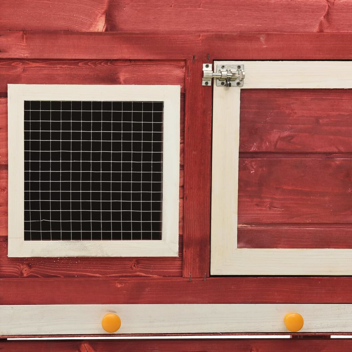 Ein rotes Holzschuppen mit einem weiß gerahmten Fenster und einer Tür. Das Fenster hat ein Drahtgeflecht und die Tür einen Riegel.