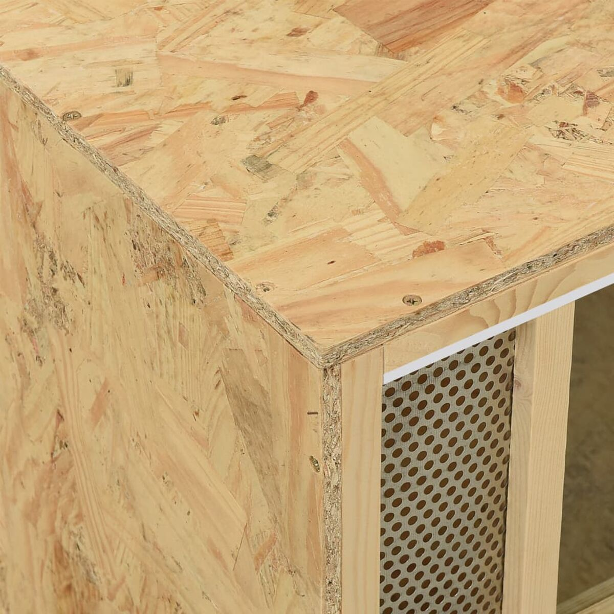 Eine Ecke einer Holzkiste zeigt eine gebohrte Metallseite. Eine weiße, gebohrte Seite wird ebenfalls gezeigt.