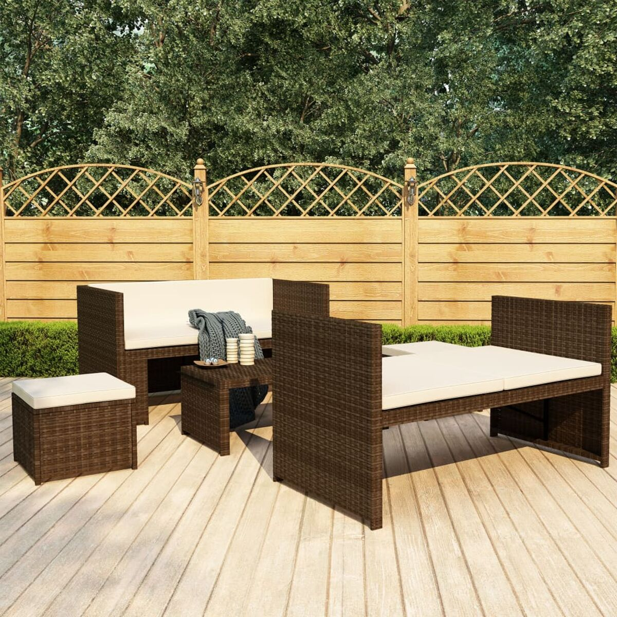 Geflochtenes Gartenmöbel-Set auf einer Holzterrasse. Enthält ein Sofa, einen Tisch und eine Ottomane.