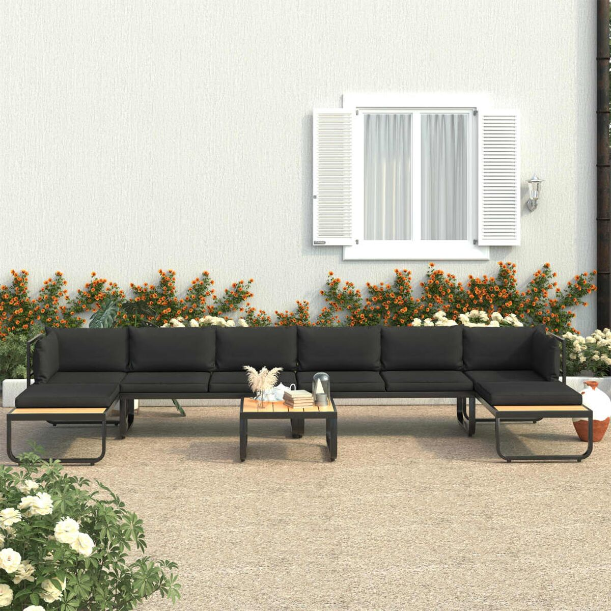 Schwarzes Outdoor-Sofaset mit Holztischen und dekorativen Pflanzen. Weißer Wandhintergrund.