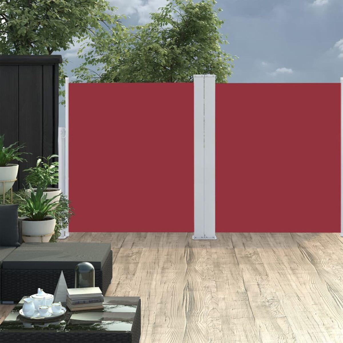 Roter Sichtschutz im Freien auf einem Holzdeck, mit Pflanzen und einer dunklen Wand im Hintergrund.
