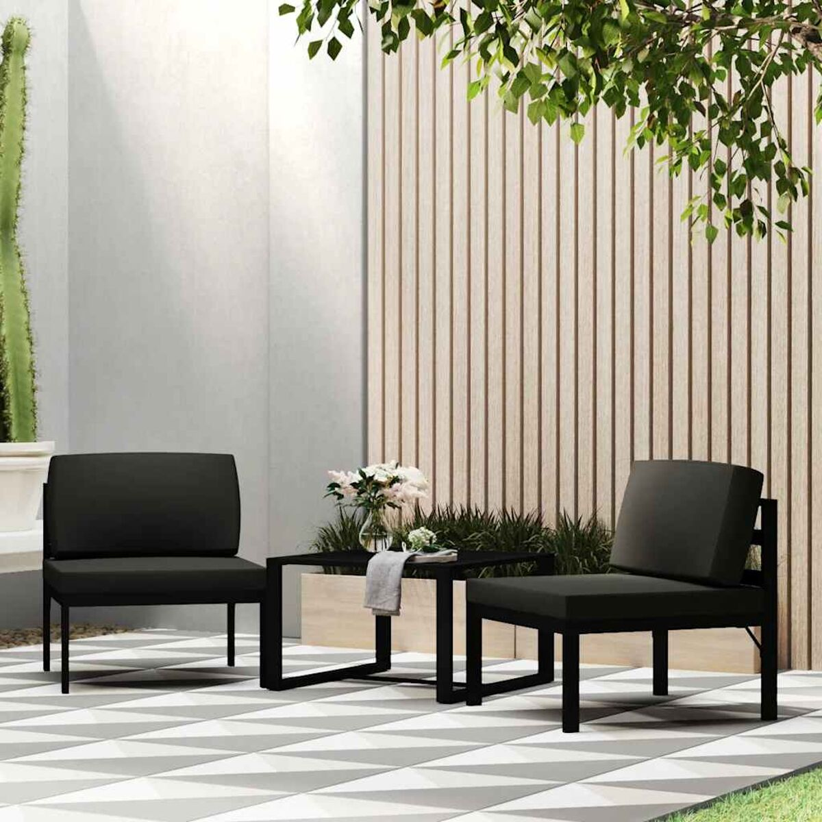 Outdoor-Terrassenset mit zwei dunklen Stühlen, einem Tisch, Pflanzen und einer Wand.