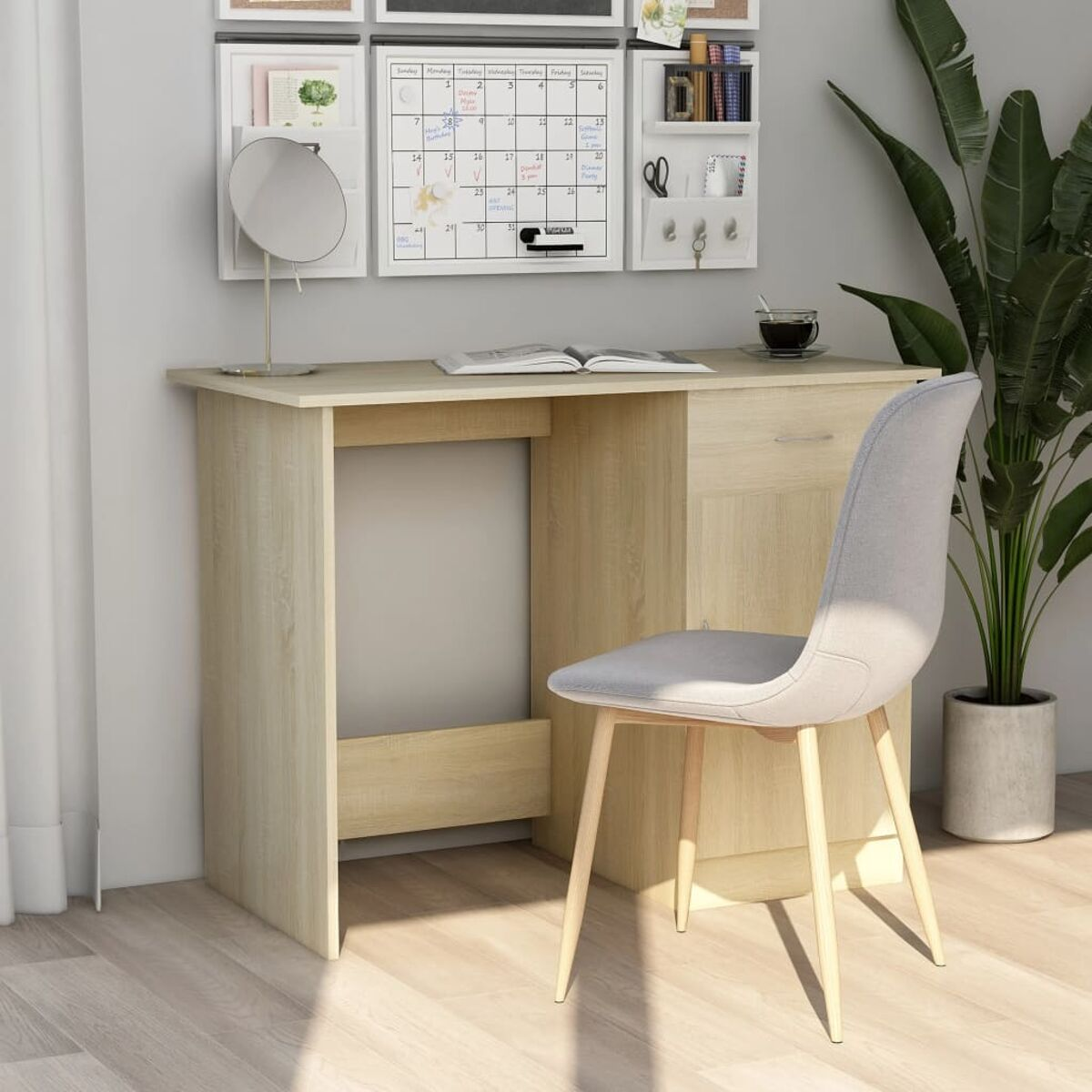 Ein heller Holzschreibtisch mit Schubladen und Stuhl, mit Wandregal und Dekorationen im Hintergrund.