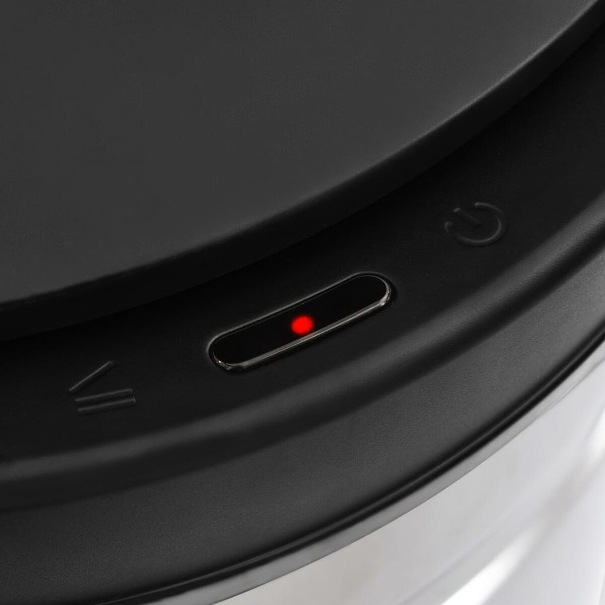 Nahaufnahme eines schwarzen Geräts mit beleuchtetem rotem Power-Knopf.