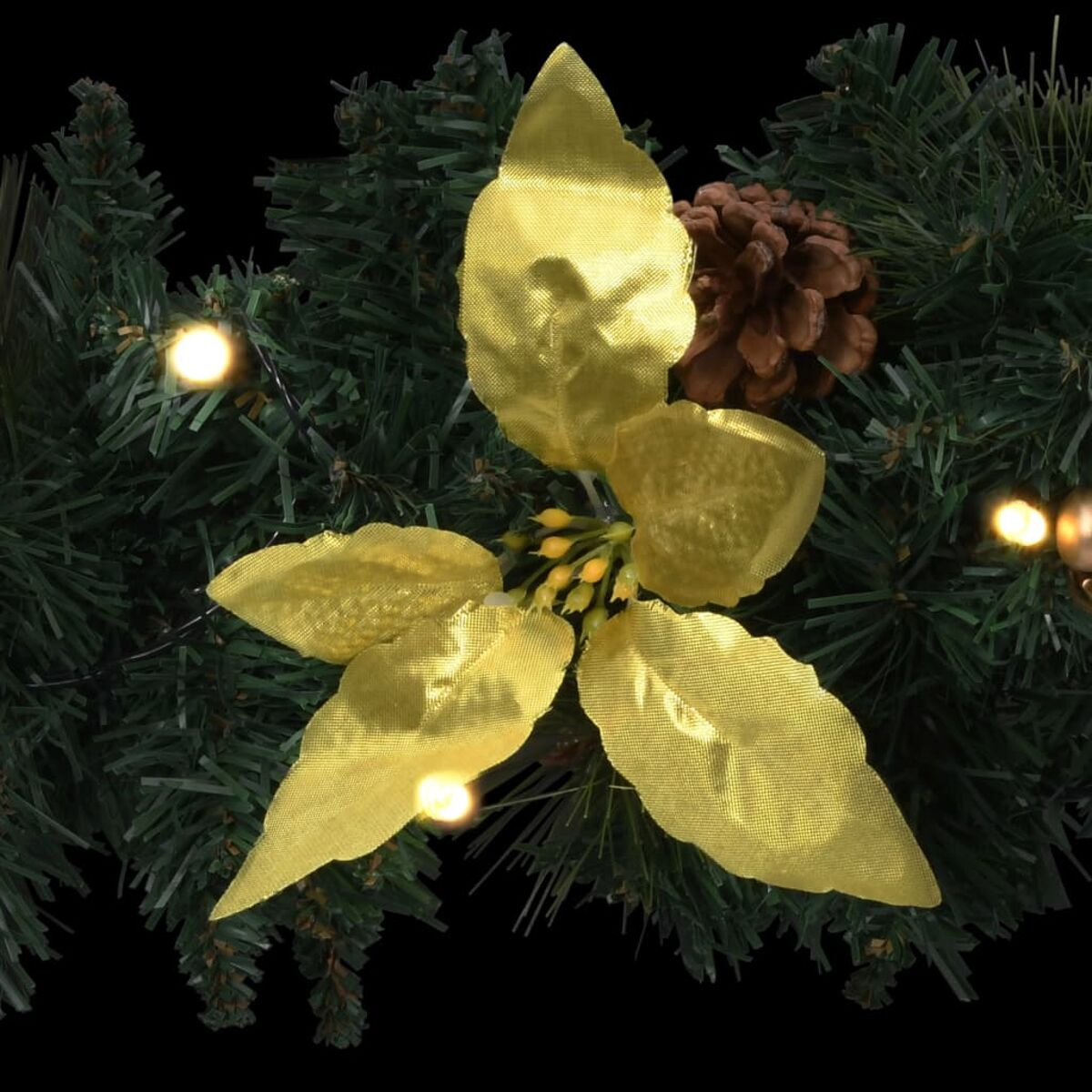 Nahaufnahme eines Weihnachtsgirlande mit Goldblättern, Tannenzapfen und Lichtern. Schwarzer Hintergrund.