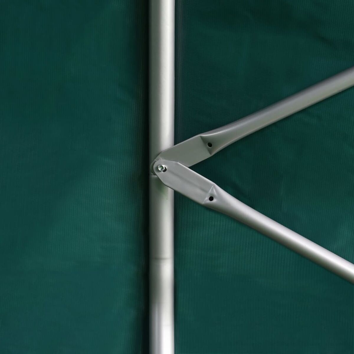 Nahaufnahme eines Metallmechanismus, der zwei Silberstangen mit grünem Hintergrund verbindet.