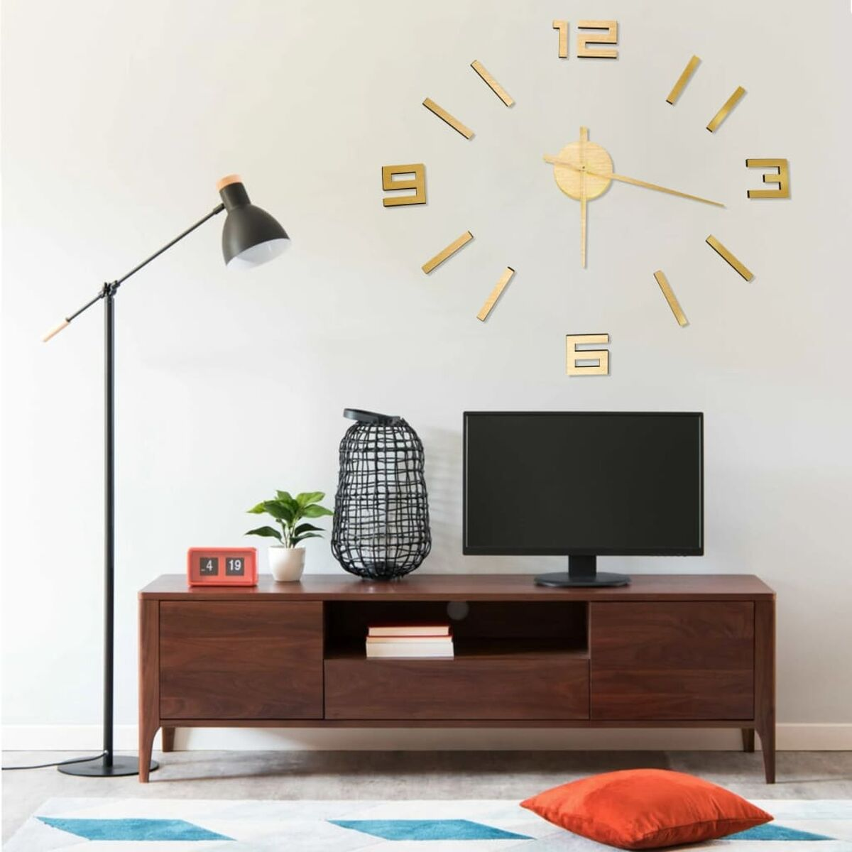 Ein modernes Wohnzimmer mit Holzschrank, TV, Uhr und Stehlampe. Weiße Wand.