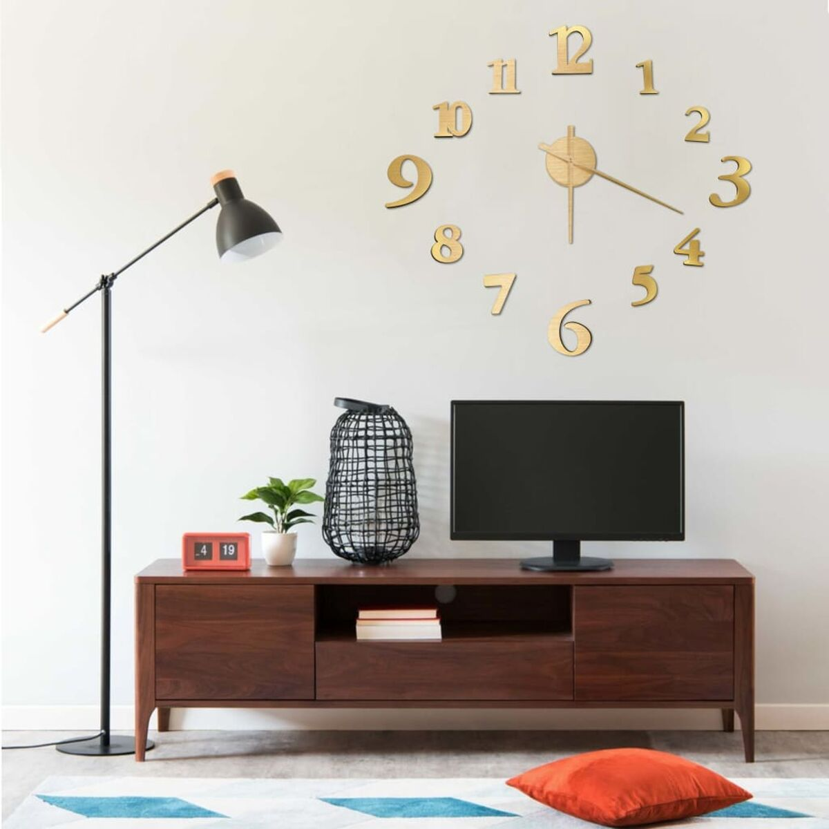 Wohnzimmer mit Uhr, Lampe, Fernseher und Schrank. Dekoriert mit einer Pflanze.