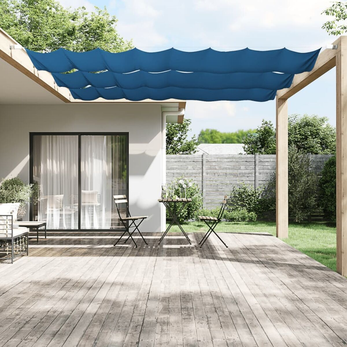 Blauer Baldachin über einem Deck. Tisch und Stühle stehen vor einem Haus.