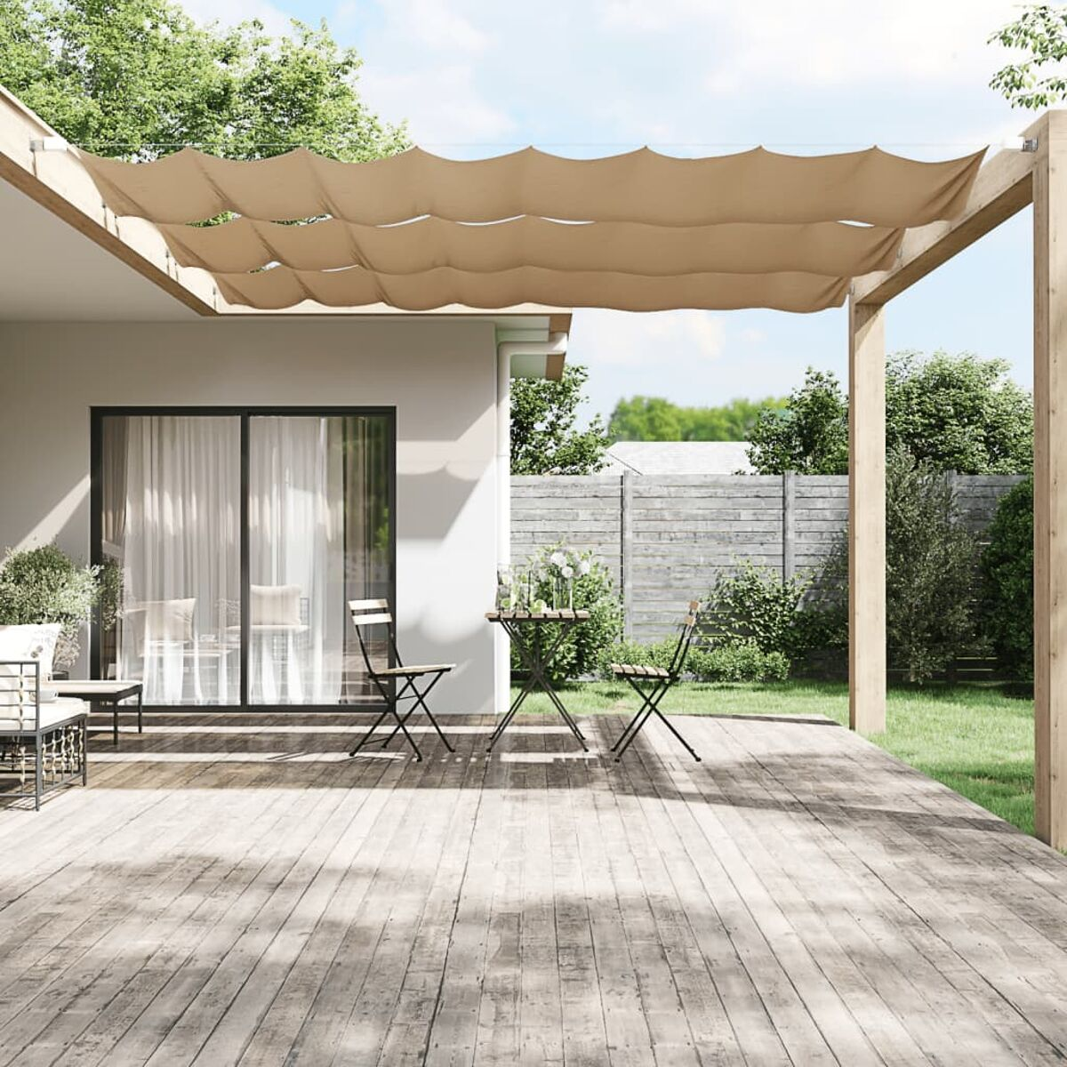 Eine Terrasse mit Holzterrasse, einer beigen Markise, einem Tisch und zwei Stühlen. Grün und ein Zaun im Hintergrund.