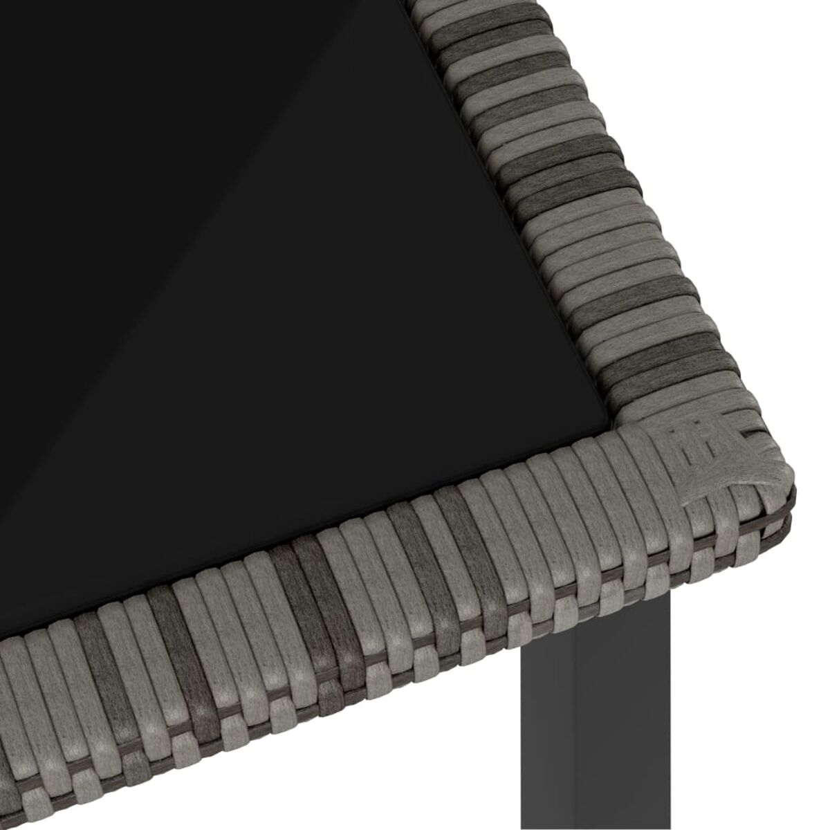 Nahaufnahme einer Tischecke. Eine schwarze Glasplatte mit grauem Weidenrand.