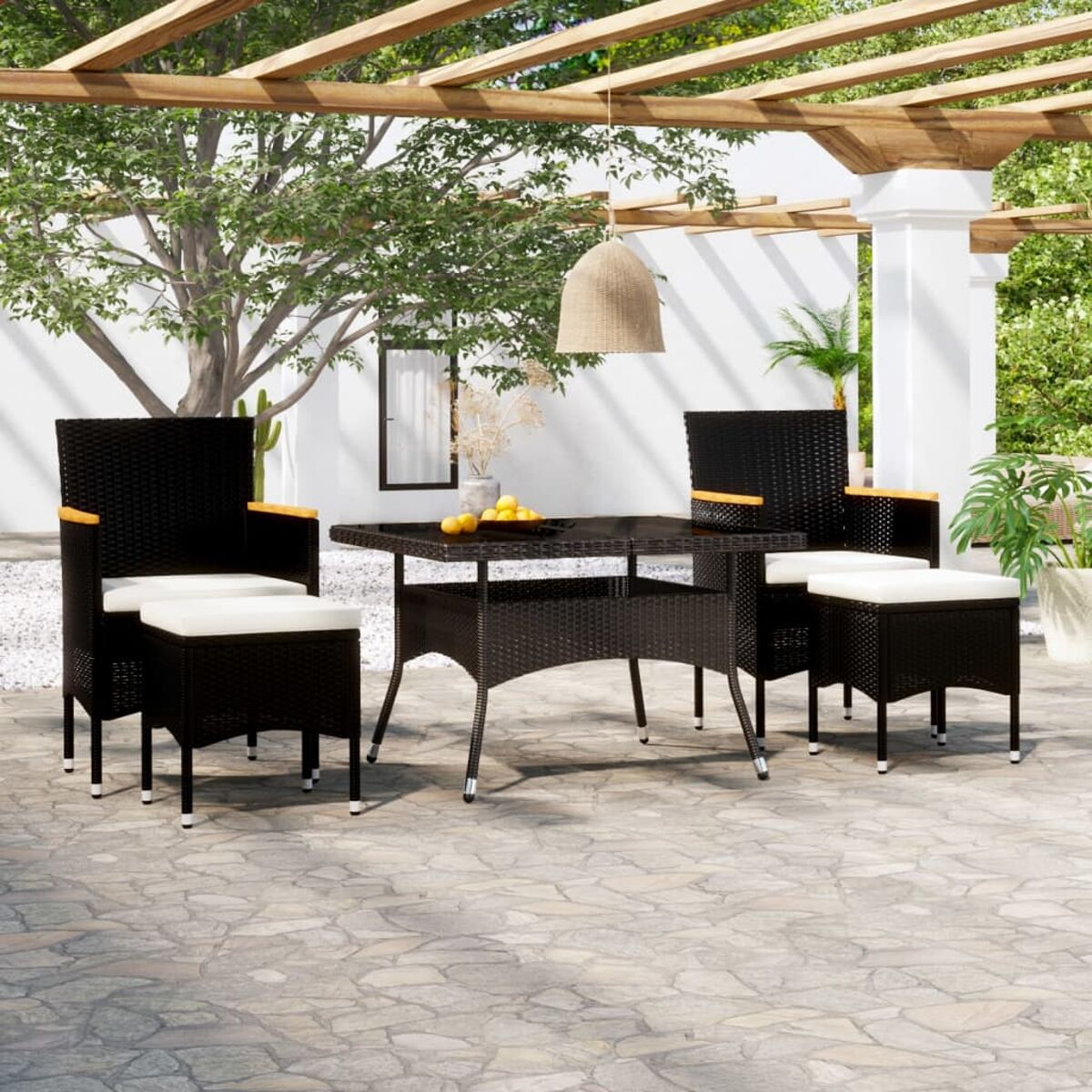 Garten-Set mit schwarzer Korbmöbel, Tisch, Stühlen und Kissen. Die Szene ist in einem Garten.