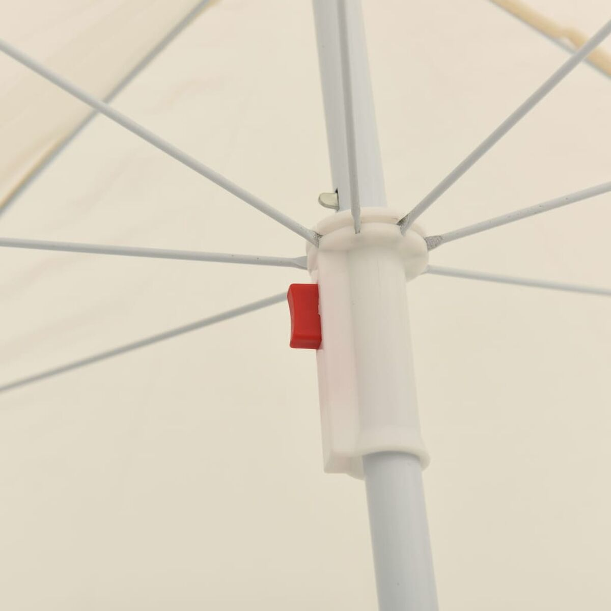 Nahaufnahme des weißen Rahmens und des cremefarbenen Stoffes eines Regenschirms. Ein roter Knopf ist sichtbar.