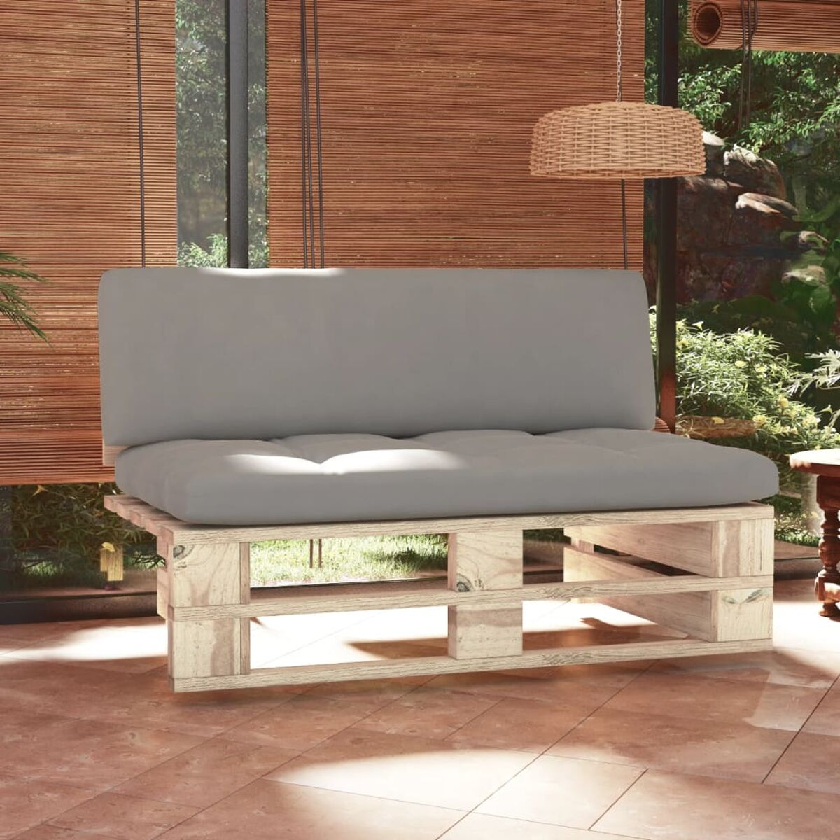 Palettensofa mit grauem Kissen. Fenster im Hintergrund.