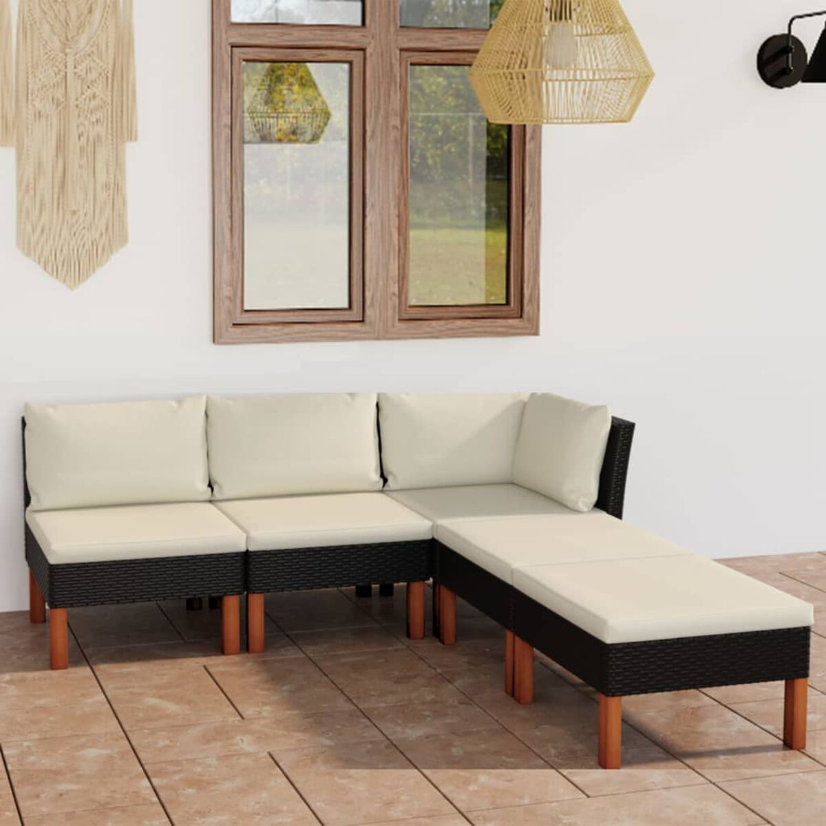 L-förmiges Outdoor-Sofa mit cremefarbenen Kissen. Holzbeine und Makramee-Wandbehang.