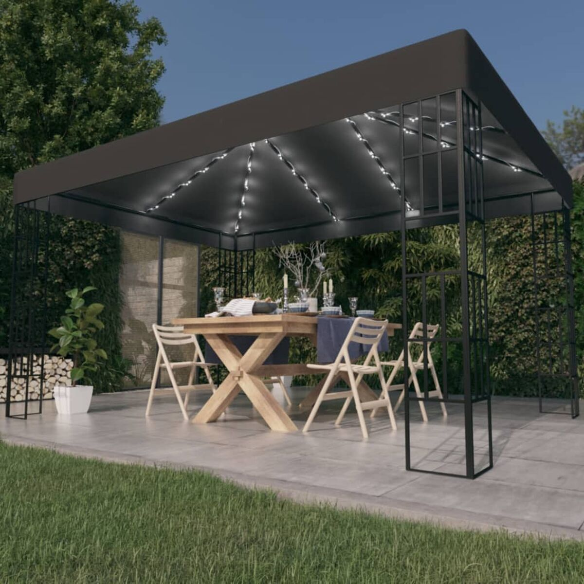 Pavillon mit Tisch, Stühlen und Lichtern.  Außenbereich in der Dämmerung.