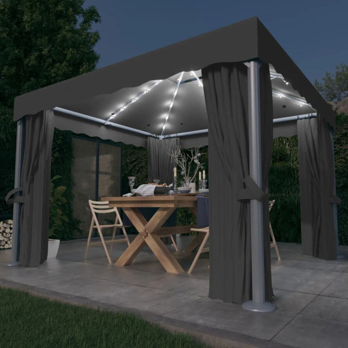Gartenpavillon-Setup bei Nacht. Es hat dunkle Vorhänge, Lichter, einen Tisch und Stühle. Bäume im Hintergrund.