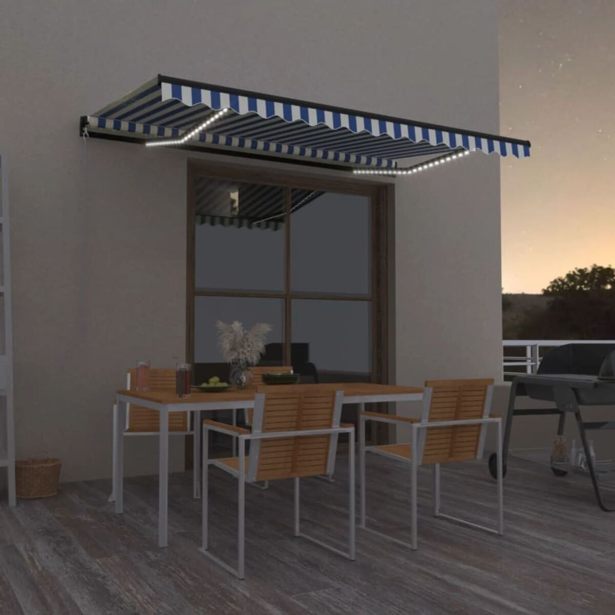 Markise über Fenster, Tisch und Stühlen auf einer Terrasse. Mit Lichtern beleuchtet. Sonnenuntergang im Hintergrund.