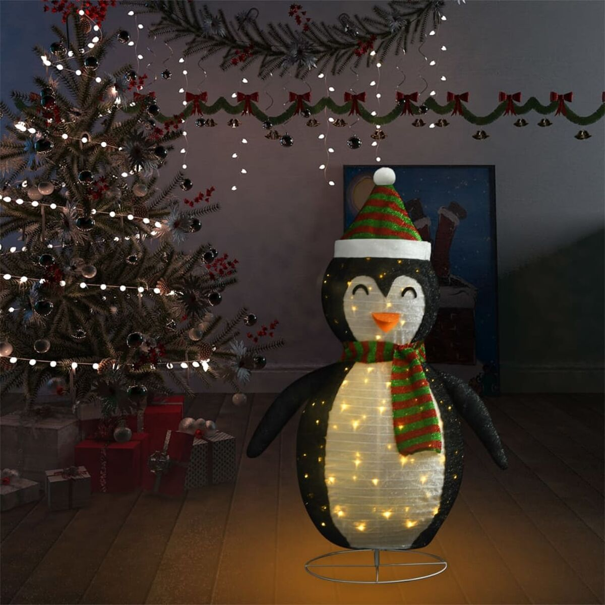 Eine Weihnachtsszene mit einer beleuchteten Pinguin-Dekoration, Weihnachtsbaum und Geschenken.
